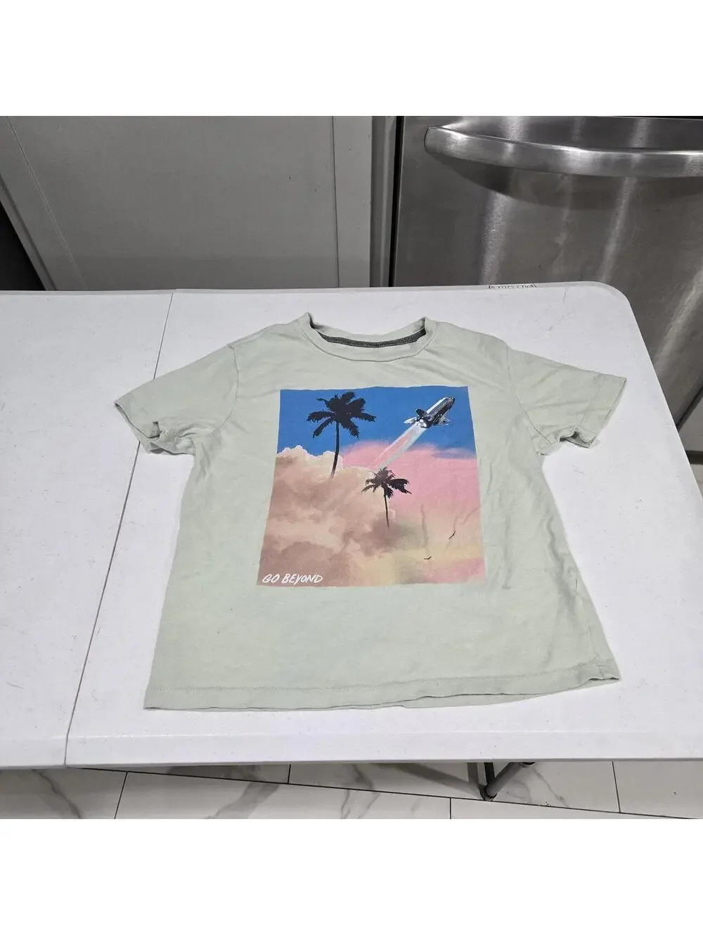 -Light green Old Navy graphic tee with palm trees and a rocket